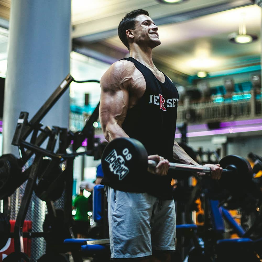 Image of a man doing barbell curls at the gym