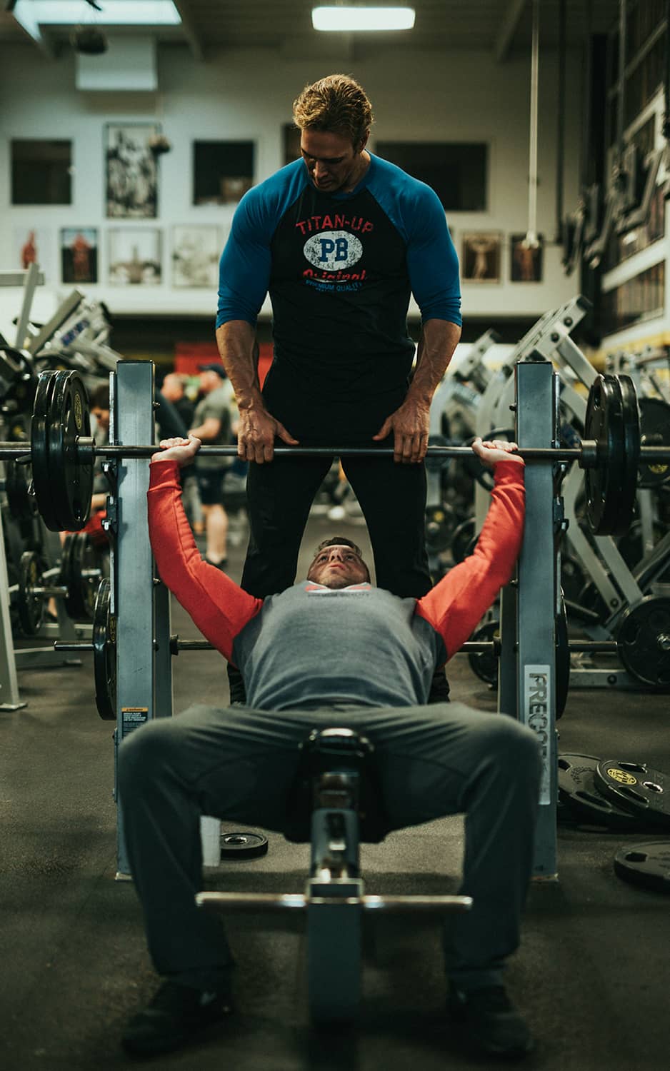 a man lifting weight with his trainer